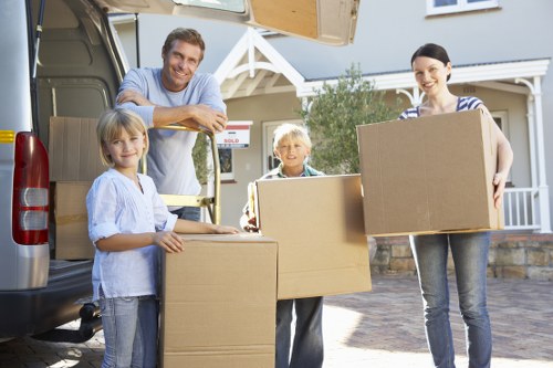 Helper carrying boxes during a house move in Bounds Green